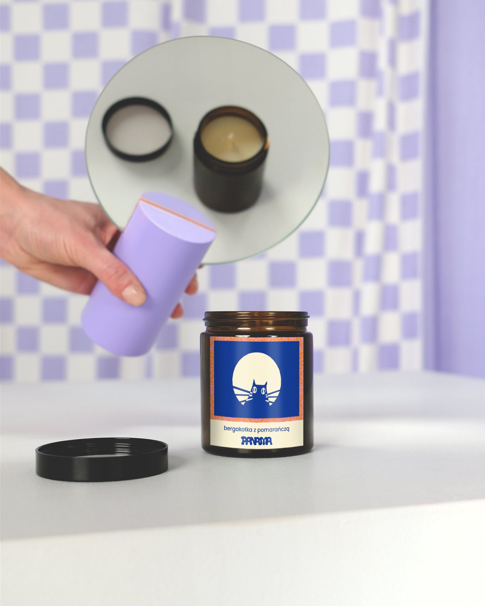 Świeczka sojowa BERGAKOTKA Z POMARAŃCZĄ, o zapachu bergamotki z pomarańczą. Granatowa etykieta z graficznym przedstawieniem głowy kota.